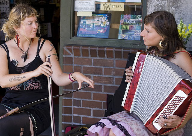 Claire and McKenzie performing in front of Left Bank Books.